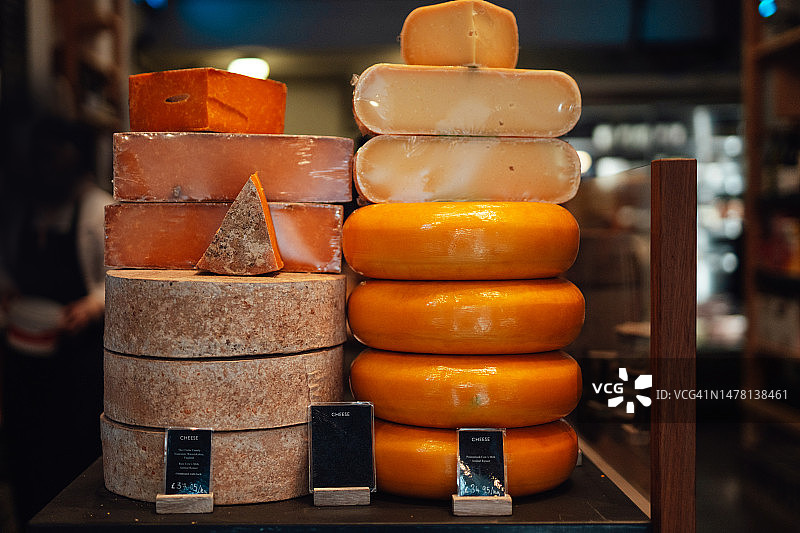 当地食品店货架上展示的各种奶酪图片素材