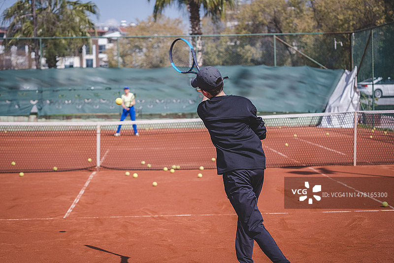 年轻的网球运动员在硬地球场上救球图片素材