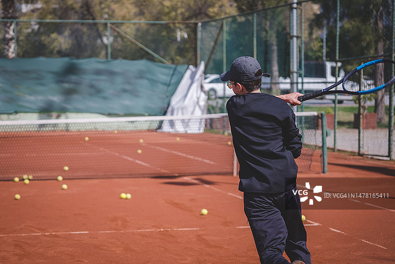 年轻的网球运动员在硬地球场上救球图片素材
