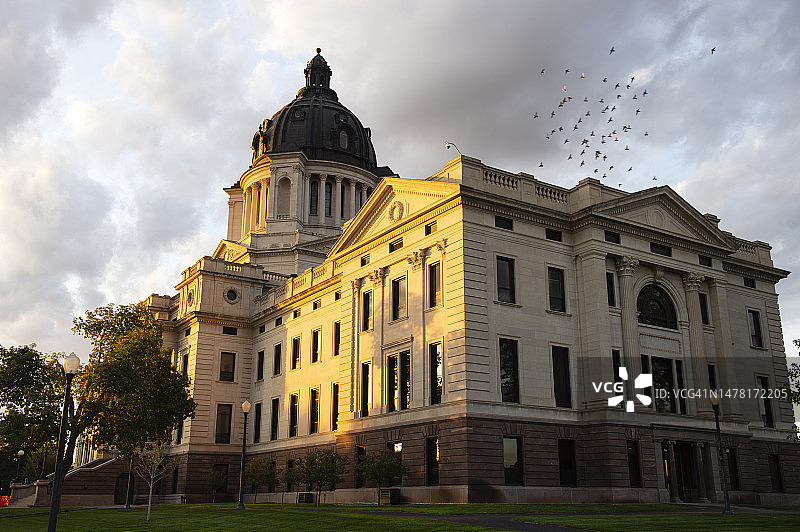 在南达科他州议会大厦上空飞行的一群鸟图片素材
