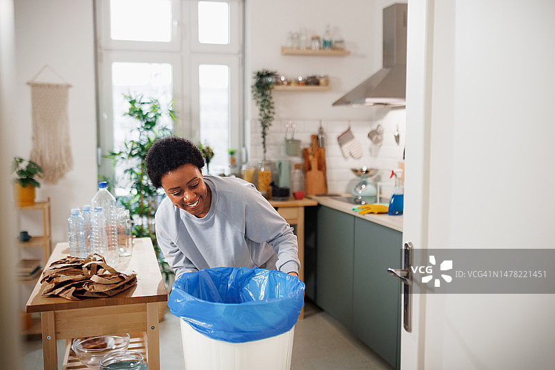 年轻漂亮的女人把包放进垃圾桶图片素材