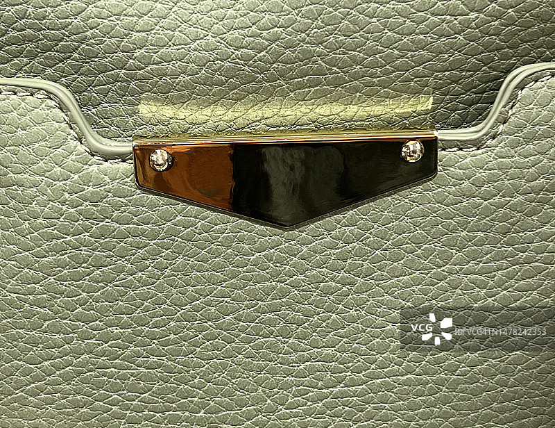 带有金属细节的绿色鹅卵石纹理手提包侧袋图片素材