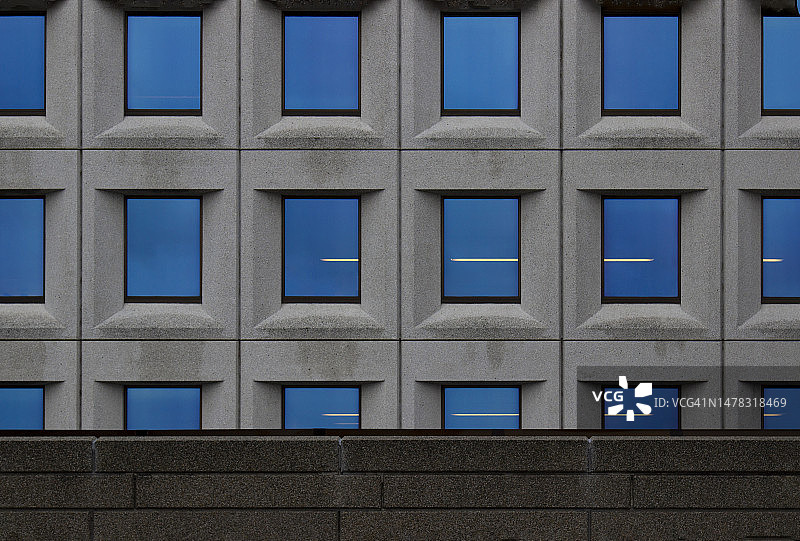 带蓝色窗户的灰色混凝土办公楼，办公场景图片素材