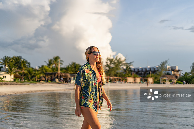 在异国情调的热带海滩上行走的女人图片素材