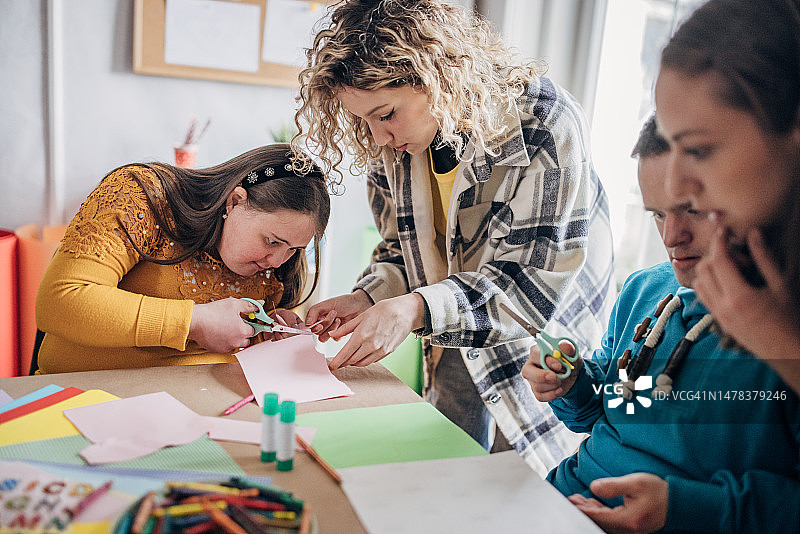 唐氏综合征和脑瘫患者在助手和动画师的帮助下进行艺术项目：残疾人保健艺术工作坊图片素材