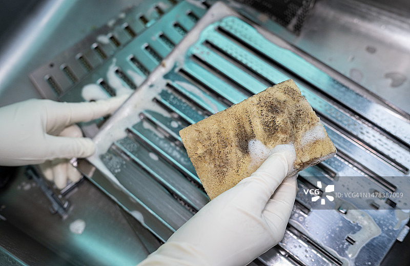 清洗水槽中脏污的炉罩过滤器后的百洁布图片素材