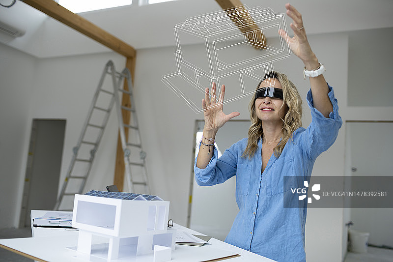 建筑师佩戴VR模拟器检查房屋模型图片素材