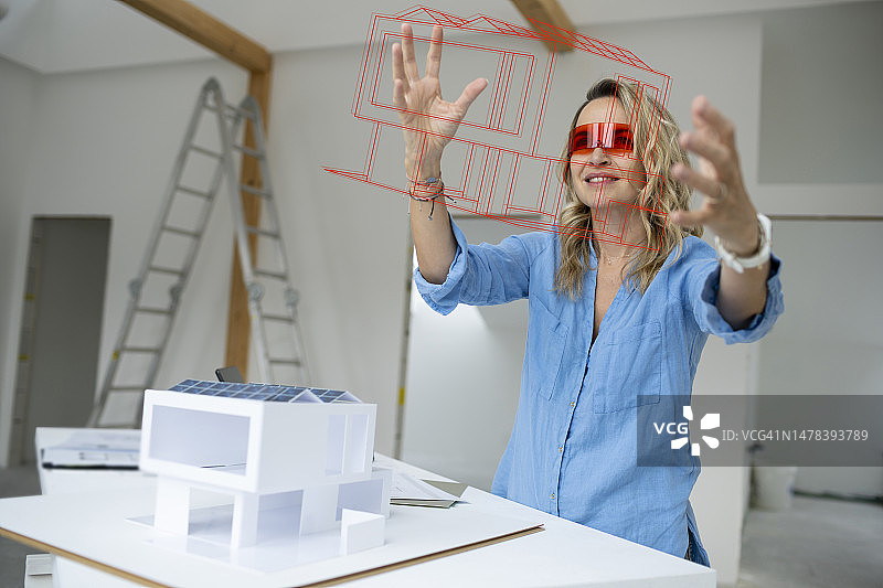 戴VR模拟器检查房屋模型的建筑师图片素材