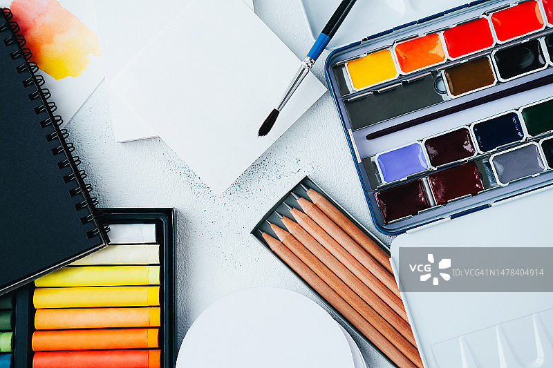 记事本、纸、画笔、水彩颜料、铅笔和彩色蜡笔图片素材