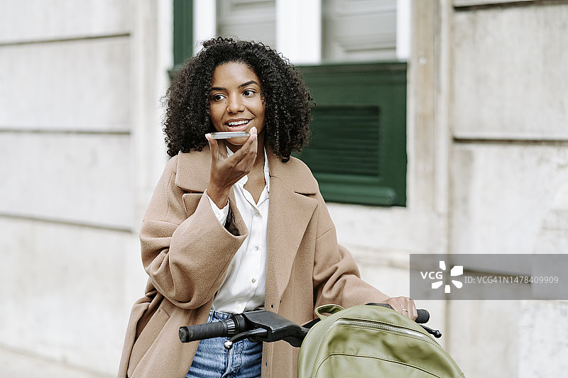 快乐的年轻女子通过智能手机发送语音邮件图片素材