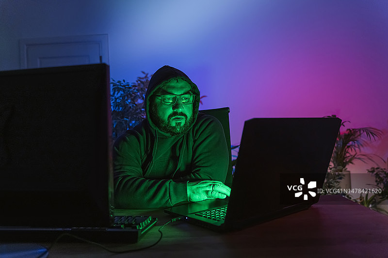 黑客在家中桌子上使用电脑图片素材