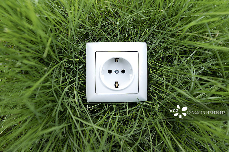 绿草地上的白色电源插座图片素材