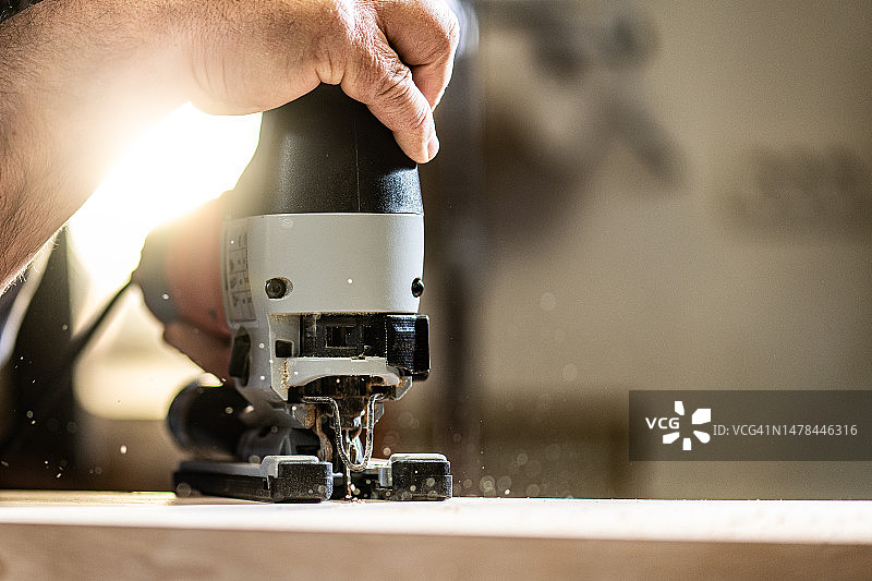 男木匠的手切割木板图片素材