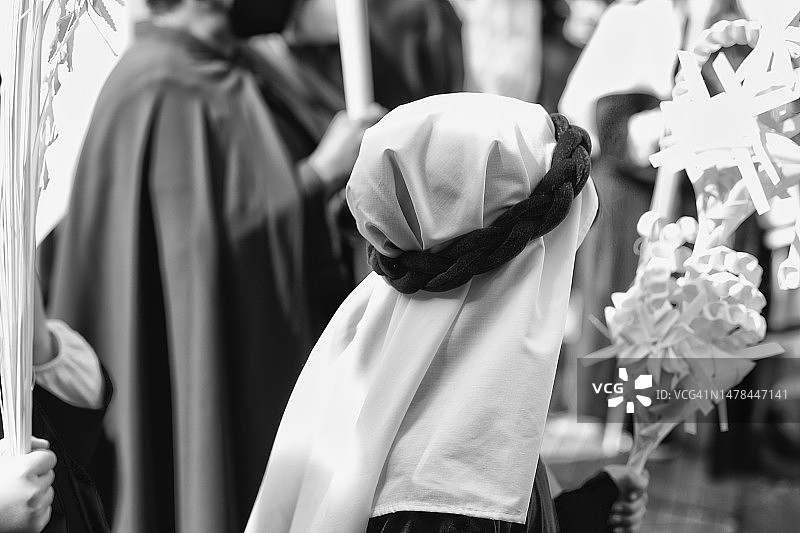 圣周期间手持棕榈树枝参加游行的人们图片素材