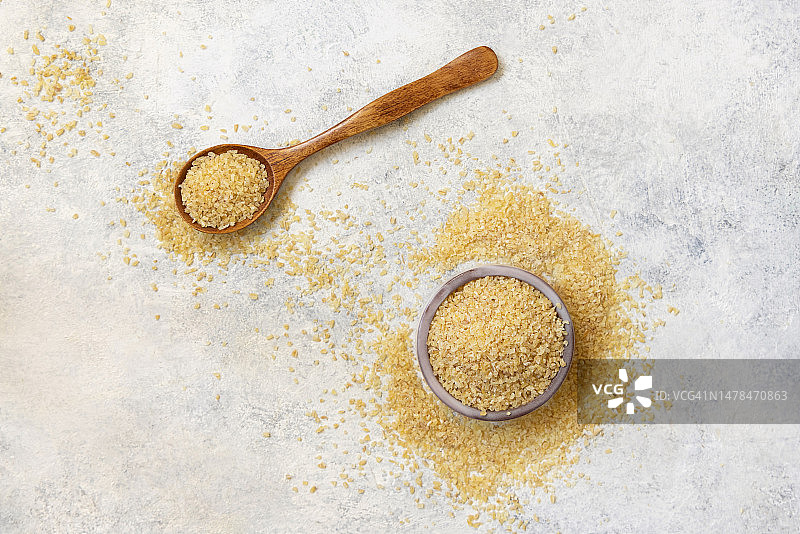 木勺和碗盛放未煮的干保加利亚小麦图片素材