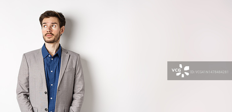 沉思的西装男商人，看向左上角图片素材