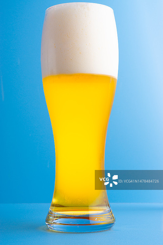 蓝色背景下的啤酒杯特写图片素材