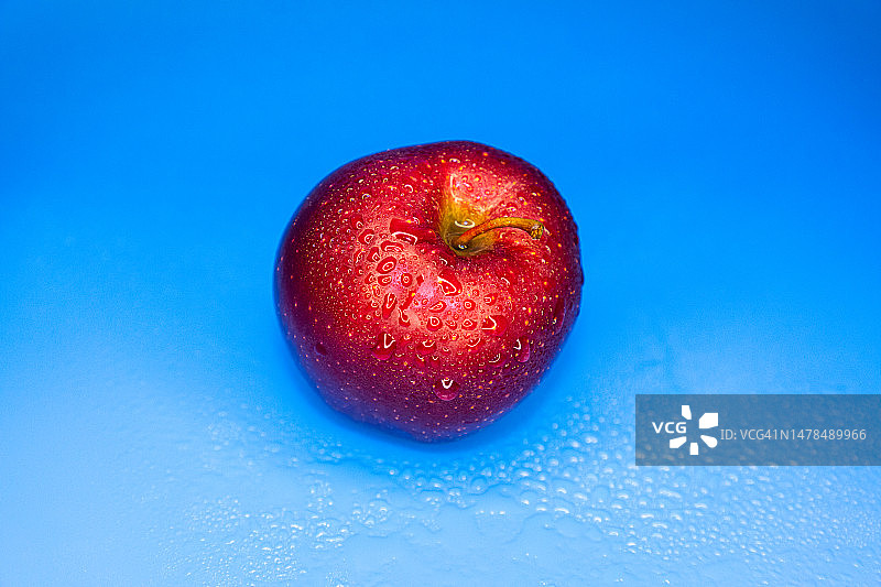 蓝色背景下的苹果特写图片素材