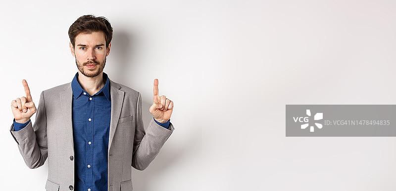 穿着西装，向上指着的严肃的络腮胡商人图片素材