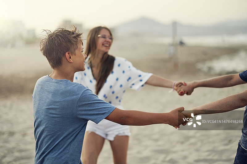 三个青少年在傍晚享受阿利坎特海滩图片素材