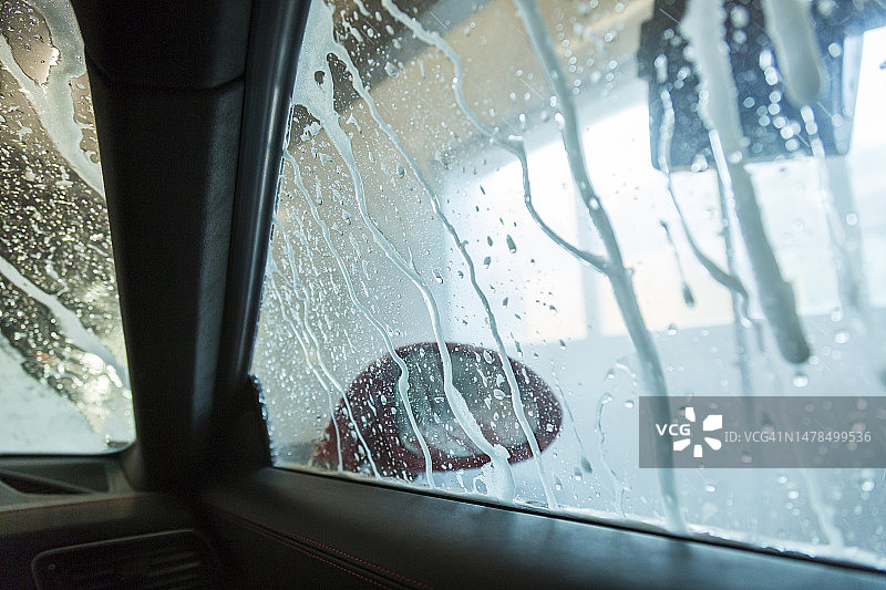 洗车房内汽车的湿挡风玻璃和车窗图片素材