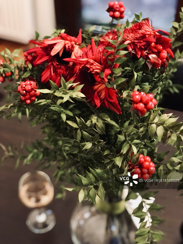 圣诞节活动：花瓶中的槲寄生与桌上的粉红玫瑰葡萄酒图片素材