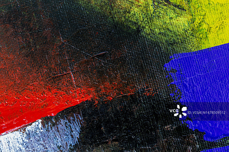 彩色丙烯颜料抽象背景的微距特写：红色、黄色、蓝色和白色在黑色背景上图片素材