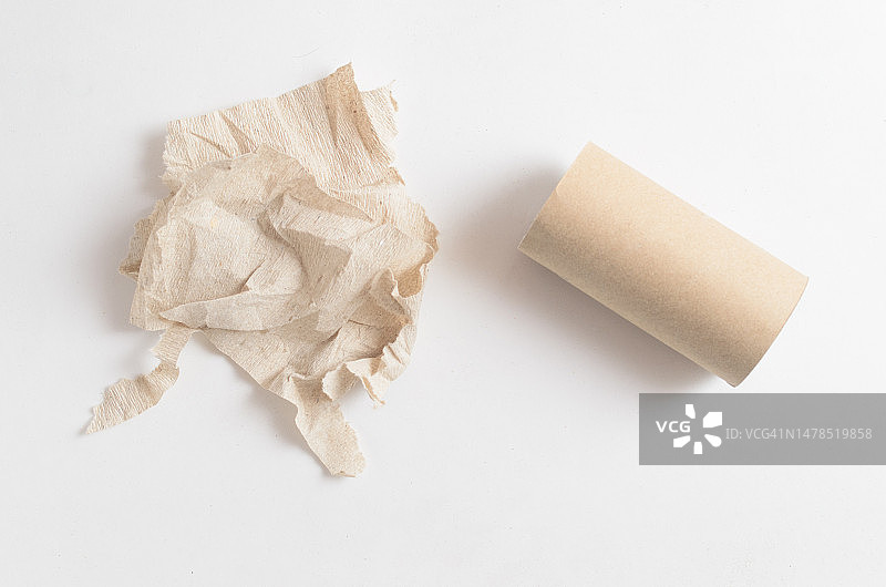 白色背景上的皱巴巴的卫生纸和空的卫生纸卷图片素材