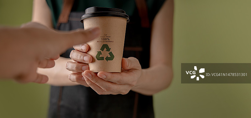 可回收包装概念：咖啡师给顾客递上一杯热咖啡，泰国曼谷图片素材