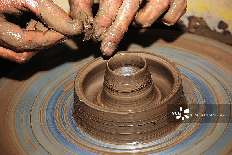 在芬兰，男子在陶轮上塑造形状的特写图片素材