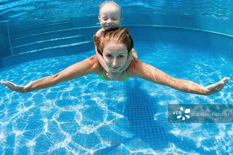 孩子和母亲在游泳池里潜水图片素材