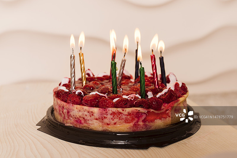 木板上的红色奶酪蛋糕和蜡烛，覆盆子蛋糕，婚礼甜点，生日派对甜点图片素材
