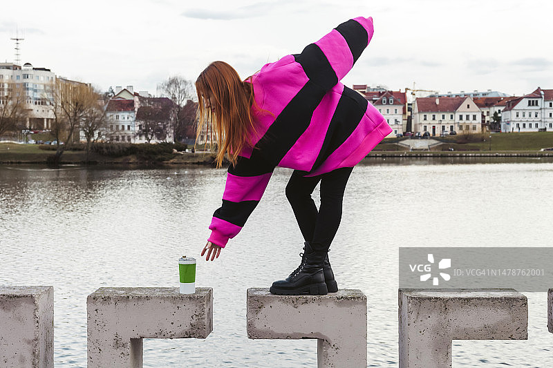 快乐年轻白人女人微笑，穿紫色毛衣，城市生活图片素材