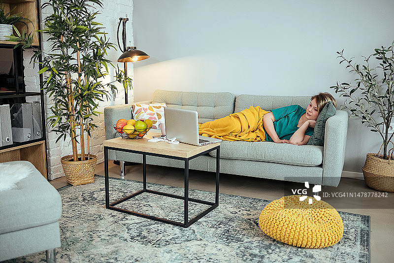 女人躺在沙发上放松图片素材