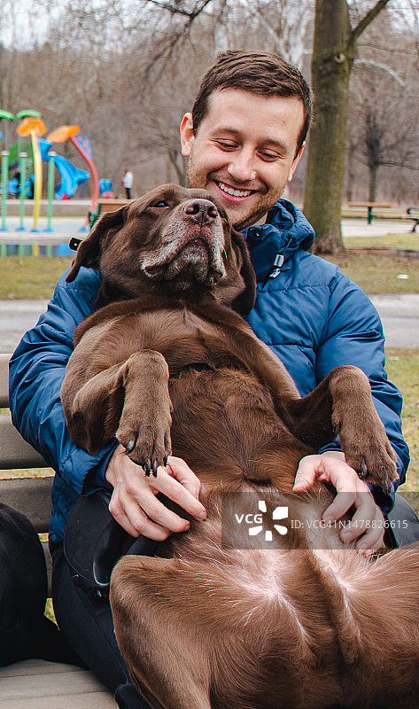 男人和他的狗在公园里图片素材