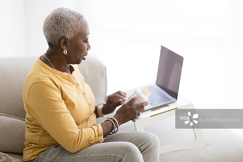 年长的黑人妇女在家中使用远程医疗服务图片素材