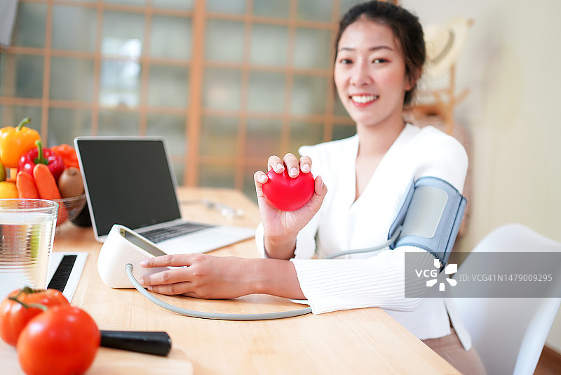 女病人手持心形测量血压特写图片素材