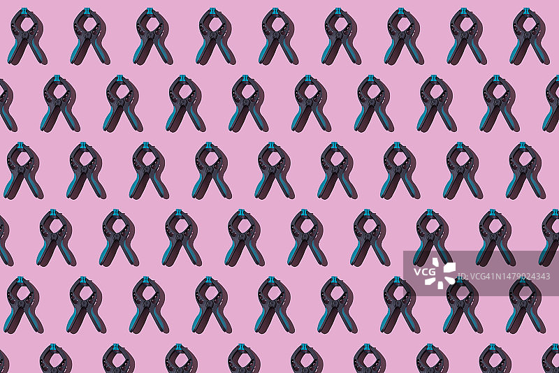 灰色和绿色虎钳粉色背景图案：压制与改革概念图片素材