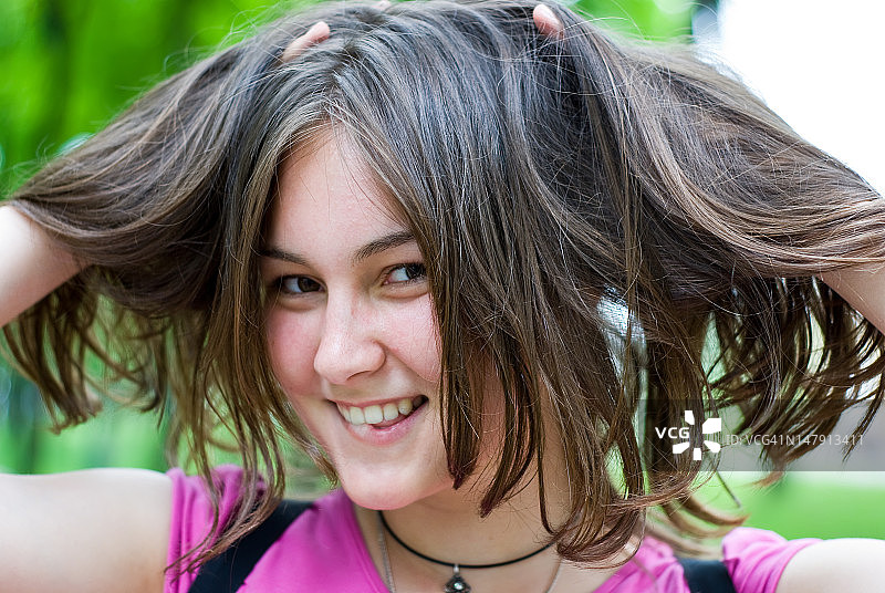 双手放在头发里的青少年女孩图片素材