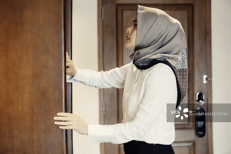 商务女性在酒店房间里准备工作，正在穿衣打扮图片素材