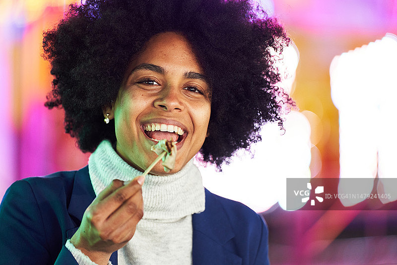 在夜间集市吃巧克力可丽饼的非洲妇女图片素材