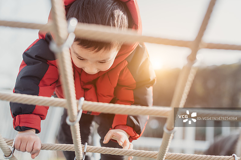 攀爬绳架的亚洲小男孩图片素材
