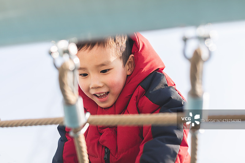 攀爬绳架的亚洲小男孩图片素材