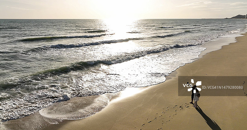 情侣在空旷海滩上自拍的航拍图片素材