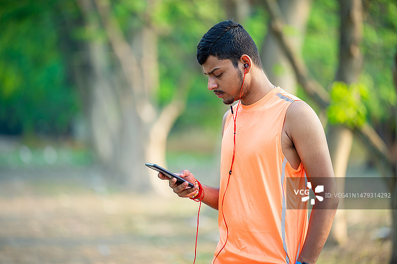 长跑后在公园休息发短信的年轻男人图片素材