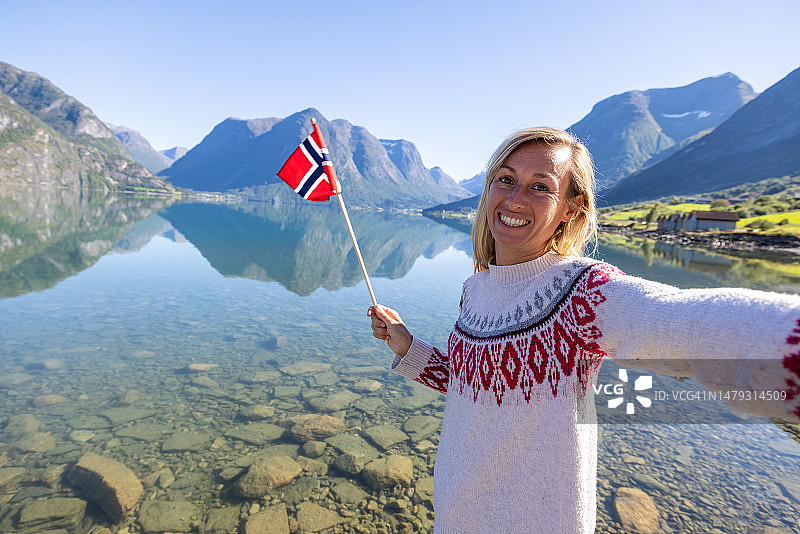 女人在湖光山色前与挪威国旗自拍图片素材