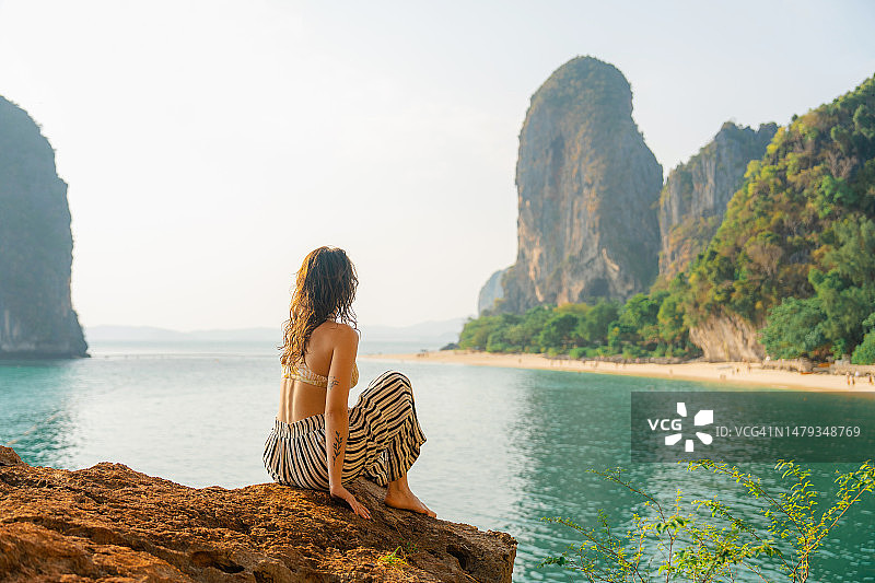 女人坐在岩石上，眺望莱利湾图片素材