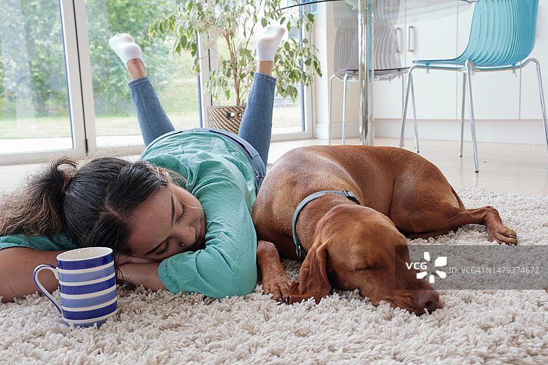 带着狗和手机在地板上的女人图片素材
