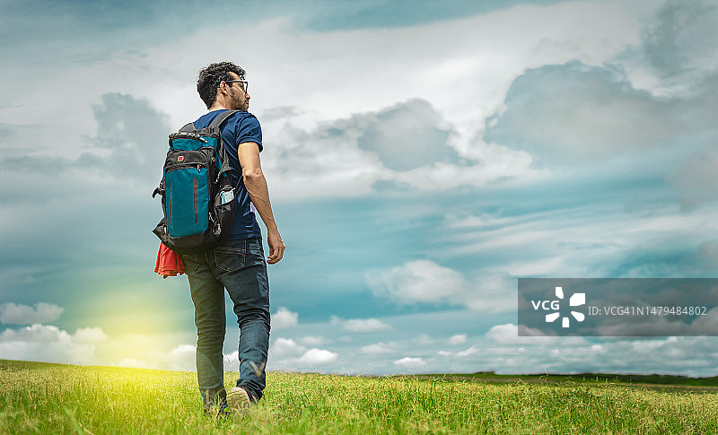 在尼加拉瓜马那瓜田野中背包远眺的男子图片素材