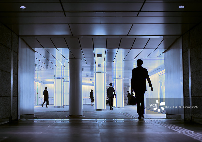 商业人士进入日本东京新宿商业区的公共地下通道图片素材